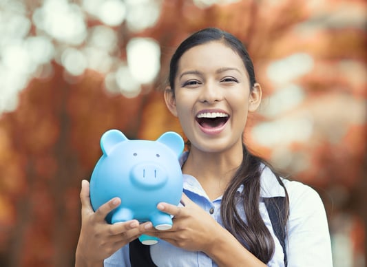 Closeup portrait happy, smiling business woman, bank employee holding piggy bank, isolated outdoors indian autumn background. Financial savings, banking concept. Positive emotions, face expressions-1