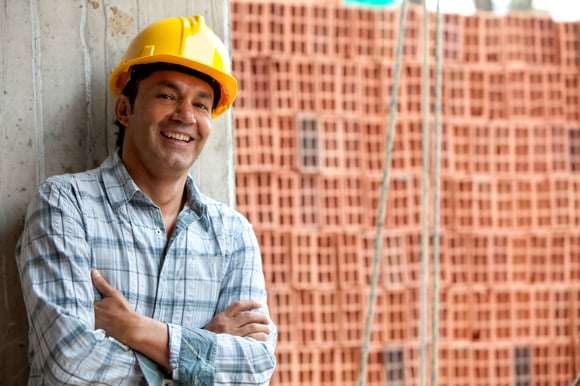 Happy male construction worker wearing a helmet and smiling